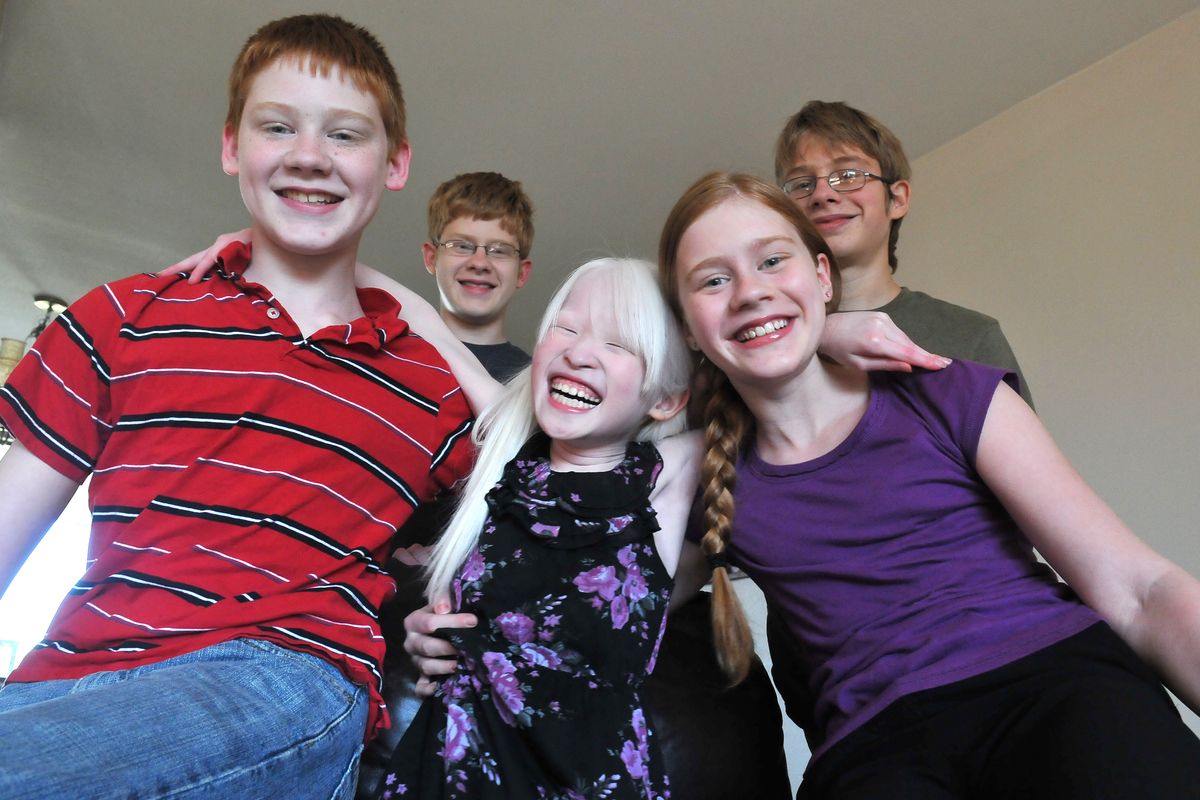Qian McCoy, center, whose name is pronounced “CHI-ehn,” now has four American siblings, shown from left, Seth, 13; Jude, 16; Emma, 15; and Caleb, 14. Qian and her adopted family live in Otis Orchards. Qian has albinism and was adopted from China, where her nickname meant “little white one.” (Jesse Tinsley)
