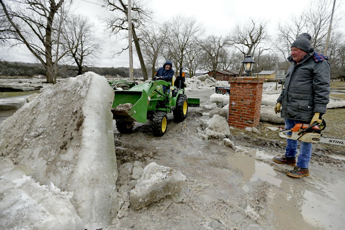 Jim Freeman, right, and his son Chad, work to clear thick ice slabs from his property in Fremont, Neb., Thursday, March 14, 2019, after the ice-covered Platte River flooded it’s banks. Evacuations forced by flooding have occurred in several eastern Nebraska communities. (Nati Harnik / Associated Press)