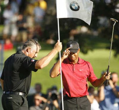 
Tiger Woods, right, tips his cap after he finished a par on the 18th green of the BMW Championship Sunday. Associated Press
 (Associated Press / The Spokesman-Review)