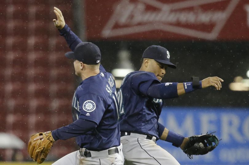 Mariners’ Robinson Cano, right, and Kyle Seager, left, celebrate after the team's baseball game against the Cincinnati Reds. The Mariners won 8-3. (John Minchillo / Associated Press)