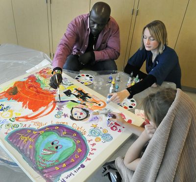 Nicholas Sironka, visiting artist (left) and Ann Walker, Arts in Healing coordinator at Providence Sacred Heart Medical Center, work on piece with a patient in the Children's Hospital, October 27, 2010 in Spokane, Wash. (Dan Pelle / The Spokesman-Review)