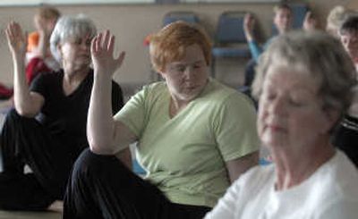 
Sue McGovney, center, does a spinal twist during a yoga class for older adults at Centerplace in Spokane Valley. 
 (Photos by J. Bart Rayniak / The Spokesman-Review)