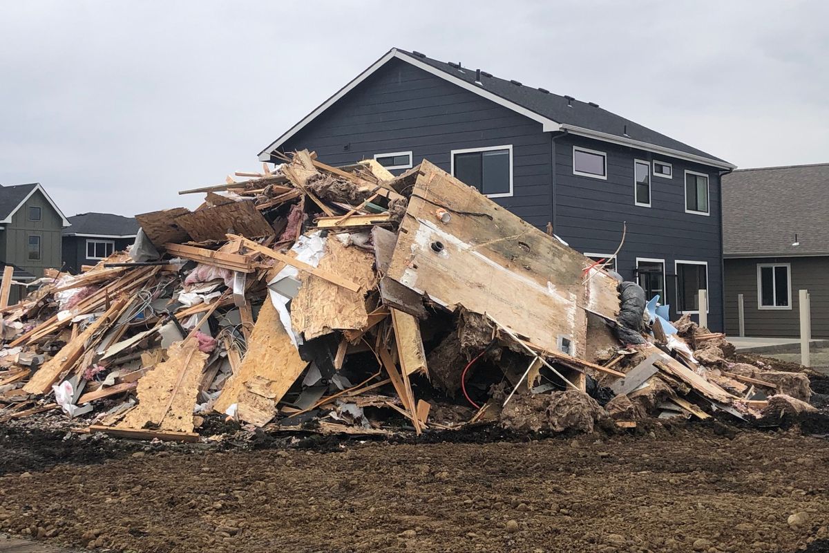 A pile of rubble is what is left of the house that was demolished Tuesday at the corner of Alsea Loop and West Platte Avenue in Post Falls. Behind the rubble is the home of neighbor Nate Shoemaker, who awoke to find an excavator ripping down the new and unoccupied house.  (Thomas Clouse/The Spokesman-Review)