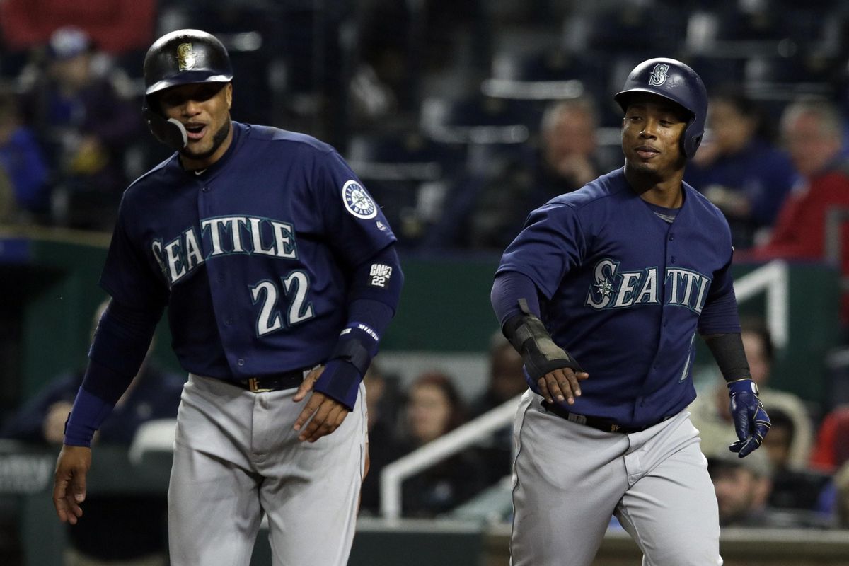Seattle’s Robinson Cano and Jean Segura, right, celebrate after scoring on a double by teammate Kyle Seager during the sixth inning Tuesday in Kansas City, Missouri. (Orlin Wagner / AP)
