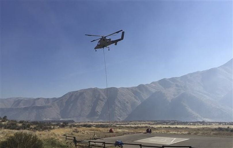 A remote-controlled Lockheed Martin K-MAX helicopter takes off Wednesday, Oct. 14, 2015, from the U.S. Forest Service’s Lucky Peak Helibase about 20 miles east of Boise, Idaho, with a water drop bucket during a successful demonstration of firefighting tasks. Federal officials say the helicopters that can operate without a pilot can fly in conditions too dangerous for manned flights and are needed to battle increasingly ferocious wildfires. (AP / Keith Ridler)