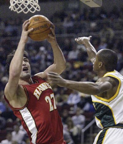 
Atlanta's Zaza Pachulia hauls down a rebound in front of Seattle's Ray Allen. 
 (Associated Press / The Spokesman-Review)