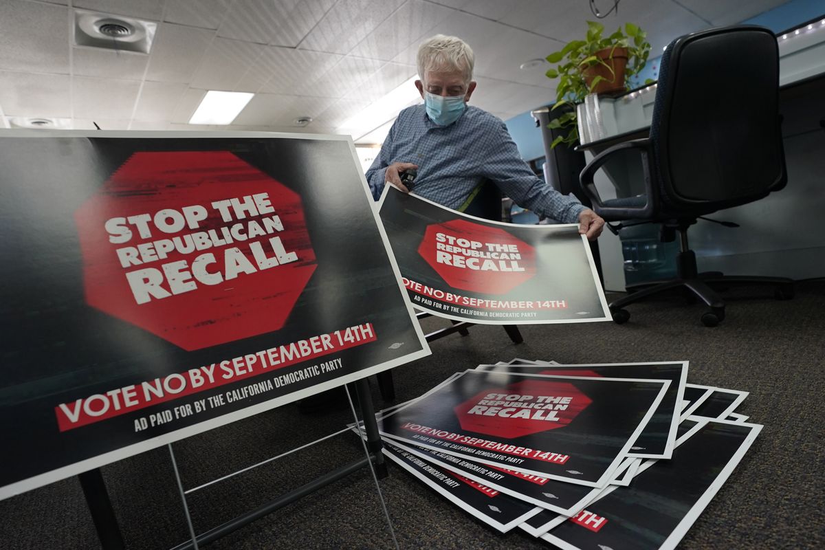 FILE - In this July 29, 2021, file photo, volunteer Merle Canfield assembles yard signs against the Sept. 14, recall election of Gov. Gavin Newsom, at the Fresno County Democratic Party headquarters in Fresno, Calif. Democratic state lawmakers Sen. Steve Glazer and Assemblyman Marc Berman called for reforming the recall election requirements, Wednesday Sept. 15, 2021. This could include increasing the number of signatures to force a recall election, raising the standards to require malfeasance on the part of the office-holder and change the current process in which someone with a small percentage of votes could replace a sitting governor.  (Rich Pedroncelli)