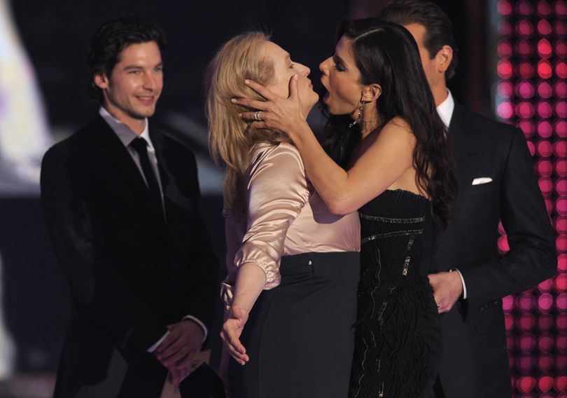 Meryl Streep, center left, and Sandra Bullock get ready to kiss as they tie for the award of best actress on stage at the 15th Annual Critics Choice Movie Awards on Friday, Jan. 15, 2010, in Los Angeles. Looking on in background right is Bradley Cooper. (Chris Pizzello / Associated Press)
