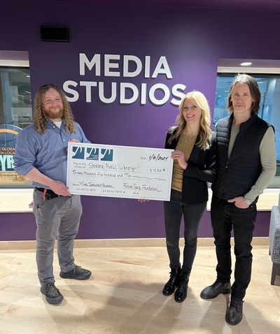 Selena and Myles Kennedy present a check to Andy Rumsey, music education specialist at the Spokane Public Library.  (Courtesy photo)