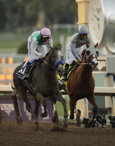 Arrogate, left, with Mike Smith aboard, crosses the finish line Saturday to win the Breeders’ Cup Classic ahead of  California Chrome. (Jae C. Hong / Associated Press)
