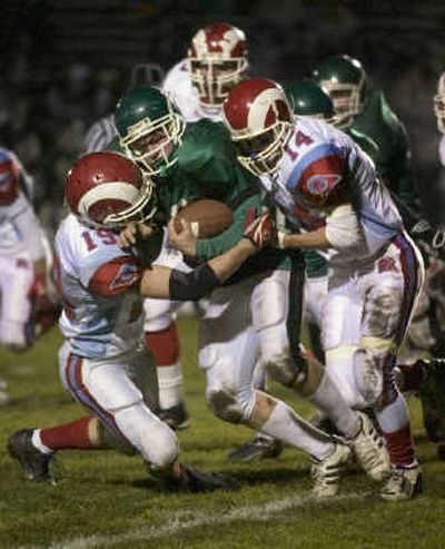 
East Valley running back Brady Brunelle is tackled by West Valley-Yakima's Chase Bosley, left, and Zeke Fife on Tuesday at East Valley High School. 
 (Colin Mulvany / The Spokesman-Review)