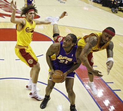 The Lakers’ Josh Powell is fouled by Cleveland’s Mo Williams, right.  (Associated Press / The Spokesman-Review)