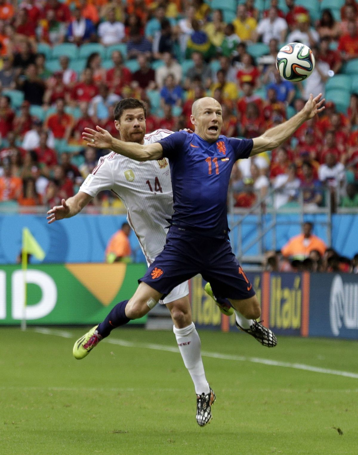 Spain midfielder Xabi Alonso (14) and Netherlands forward Arjen Robben tussel for the ball during the first half in Salvador, Brazil. (Associated Press)