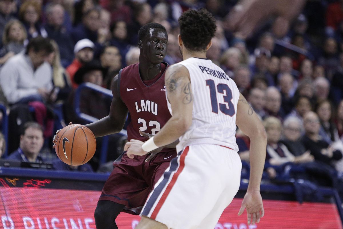 Loyola Marymount guard Buay Tuach (22) dribbles the ball while defends by Gonzaga guard Josh Perkins (13) during the first half of an NCAA college basketball game in Spokane, Thursday, Jan. 12, 2017. (Young Kwak / Associated Press)