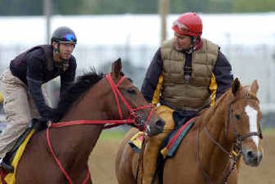 Arkansas Derby champion Afleet Alex, with jockey Jeremy Rose, left, is led across the track by trainer Tim Ritchey for a morning workout Tuesday at Churchill Downs.
(Associated Press / The Spokesman-Review)