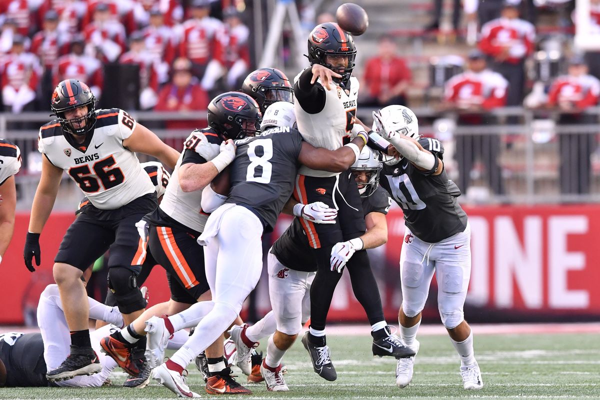 Oregon State quarterback DJ Uiagalelei releases the ball as he is enveloped by Washington State’s defense during the second half Saturday at Gesa Field in Pullman.  (Tyler Tjomsland/The Spokesman-Review)