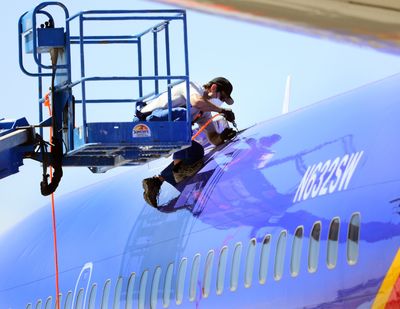 A member of the National Transportation and Safety Board cuts away a portion of a Southwest Airlines plane’s fuselage earlier this month after a hole blew open during a flight. (Associated Press)