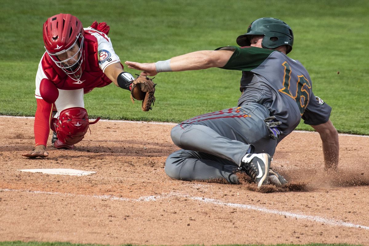 Boise Hawks outfielder Daniel Jipping slides safely into home as Spokane Indians catcher Kevin Mendoza just misses the tag in the top of the seventh inning at Avista Stadium, Sunday, June 17, 2018. (Colin Mulvany / The Spokesman-Review)
