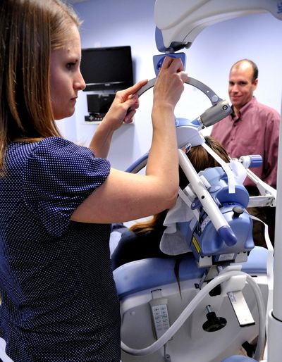 Psychiatrist Dr. Scott Babe, back right, looks on as technician Megan Hogland positions the transcranial magnetic stimulation machine for a patient at Samaritan Regional Mental Health Center in Corvallis, Ore., on June 1. (Associated Press)