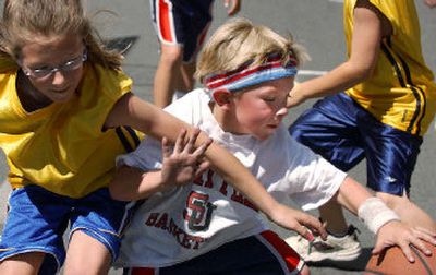 
Jaxon Woodward, 5, of Seattle, fights for a loose ball in his first game of the day Saturday. Woodward, whose team included his big sister and won one game, was one of two 5-year-olds playing in Hoopfest.
 (Photos by Joe Barrentine/ / The Spokesman-Review)