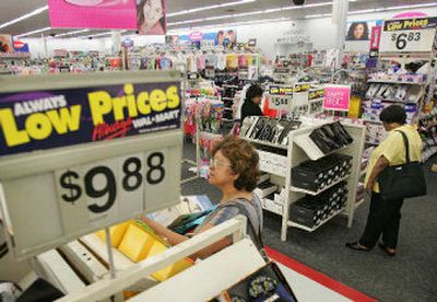 
Shoppers examine shoes at a Wal-Mart, in Walpole, Mass. Wal-Mart Stores Inc. announced more affordable health care for some of its workers Monday in the latest shot in a battle with critics for the hearts of consumers. 
 (Associated Press / The Spokesman-Review)