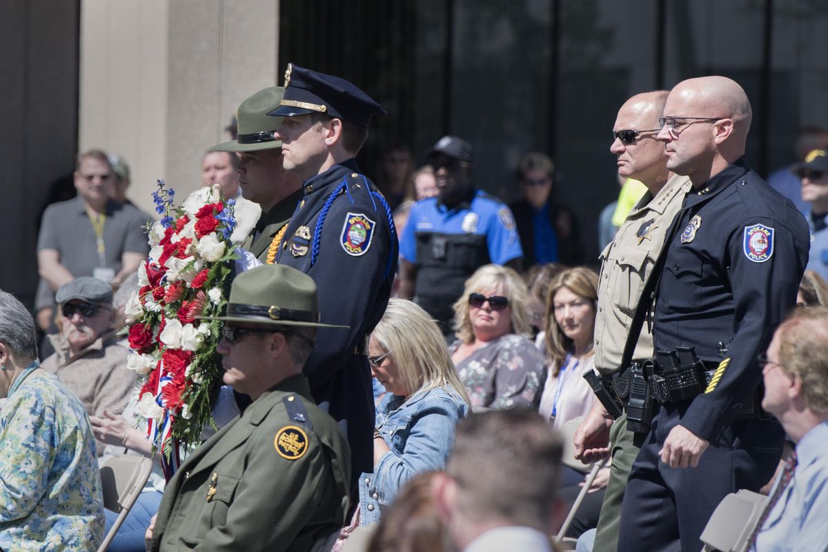Spokane Police Chief Craig Meidl, right, and Spokane Sheriff Ozzie Knezovich, second from right, walk to the Spokane Law Enforcement Memorial to lay a wreath for their respective departments Tuesday, May 8, 2017 during annual service at the memorial. (Jesse Tinsley / The Spokesman-Review)