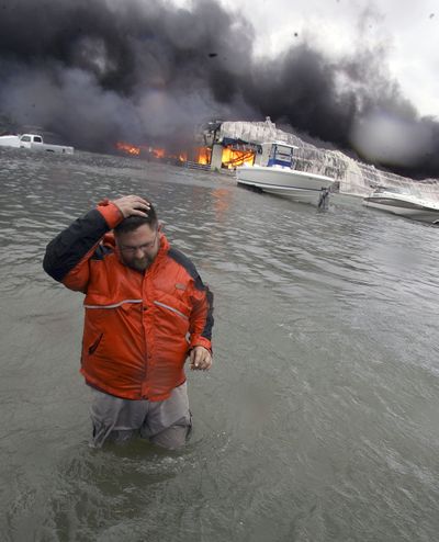 With Hurricane Ike offshore, Michael Gardner walks in high water in front of a burning marina warehouse Friday in Galveston, Texas. Firefighters, unable to reach the structure, had to let it burn. (Associated Press / The Spokesman-Review)