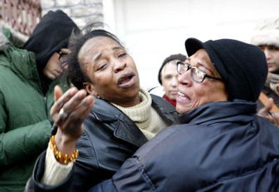 
Two women thought to be  family members comfort one another  Thursday at the scene of a fire that  killed nine  people, including  eight children,   in the Bronx borough of New York. 
 (Associated Press / The Spokesman-Review)