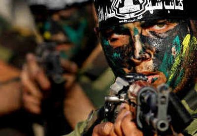 
Palestinian gunmen from Al Aqsa Martyrs Brigades, a militant group linked to the Fatah Movement, have their faces painted with camouflage as they take part in a rally in the southern Gaza Strip on Sunday. 
 (Associated Press / The Spokesman-Review)