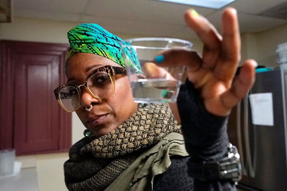 Angela Stamps holds a sampling of tap water Jan. 6 in Flint, Mich.  (Carlos Osorio)