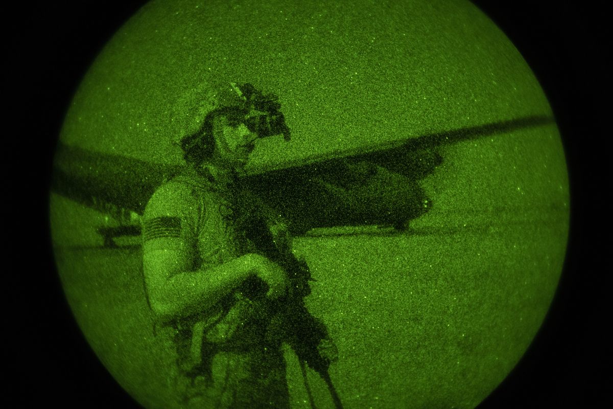 U.S. Army Spc. Dominic Deitrick, assigned to the 1-186th Infantry Battalion, Task Force Guardian, Combined Joint Task Force - Horn of Africa, seen through a night-vision device, provides security for a 75th Expeditionary Airlift Squadron (EAS) C-130J Super Hercules during unloading and loading operations Friday, June 12, 2020 at an unidentified location in Somalia. No country has been involved in Somalia