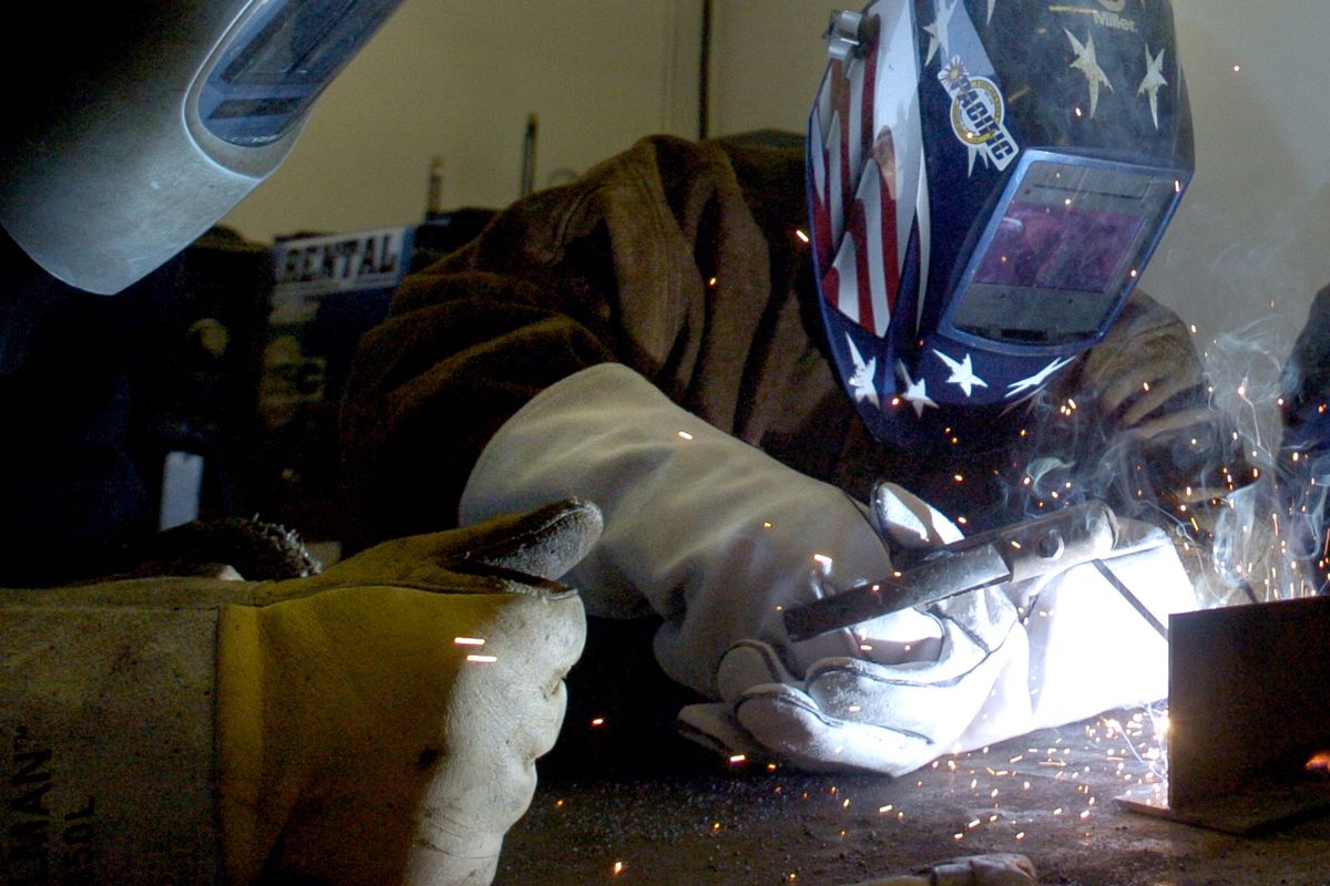 Pvt. Jessica Equihua tries her hand at welding as Hopkins looks on. Pacific Welding is training about 75 soldiers. (Joe Barrentine / The Spokesman-Review)