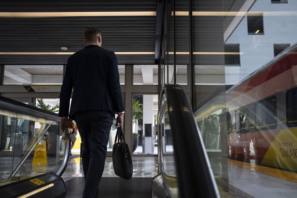 A passenger approaches a train at the Brightline Miami station.  (Thomas Simonetti/For The Washington Post)