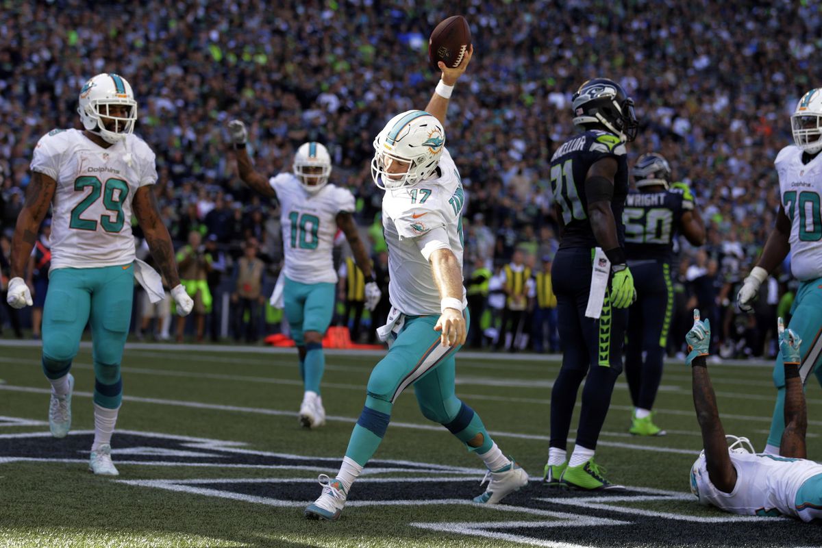 Miami QB Ryan Tannehill spikes the ball after scoring a touchdown against the Seattle Seahawks which put the Dolphins ahead 10-6 late in the second half. (Stephen Brashear / AP)