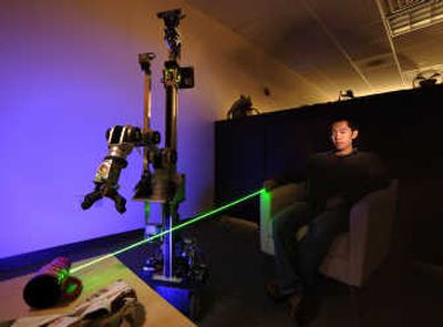 
Using a laser pointer, Hai Nguyen, a research student in Georgia Tech's Ph.D. program in robotics, instructs the El-E robot to pick up a cup at the Health Systems Institute in Atlanta. Associated Press
 (Associated Press / The Spokesman-Review)