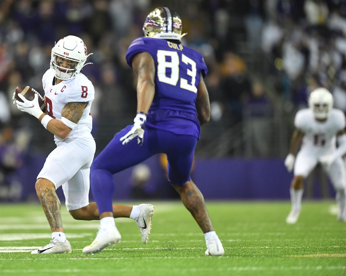 Washington State nickel Armani Marsh, left, looks for running room after making an interception as Washington tight end Devin Culp tries to stop him during the second half of the Apple Cup on Nov. 26, 2021, at Husky Stadium in Seattle.  (Tyler Tjomsland/The Spokesman-Review)
