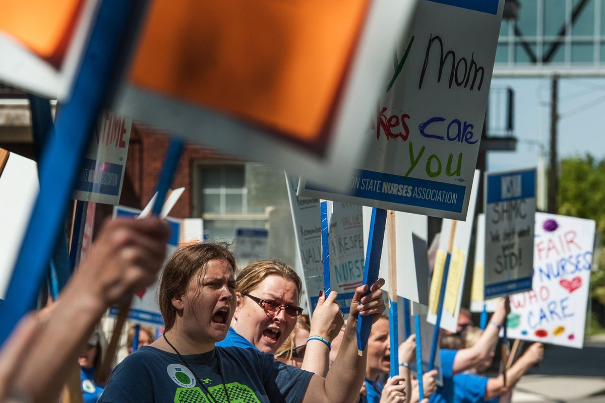 Amber Walker, center left, demonstrates alongside her mother, Yvonne Walker, near Providence Sacred Heart Medical Center on Thursday, May 9, 2019. Yvonne Walker has been a registered nurse at Sacred Heart for 19 years and works in the adult psychiatric unit. Sacred Heart nurses are demanding a more favorable union contract. (Kathy Plonka / The Spokesman-Review)