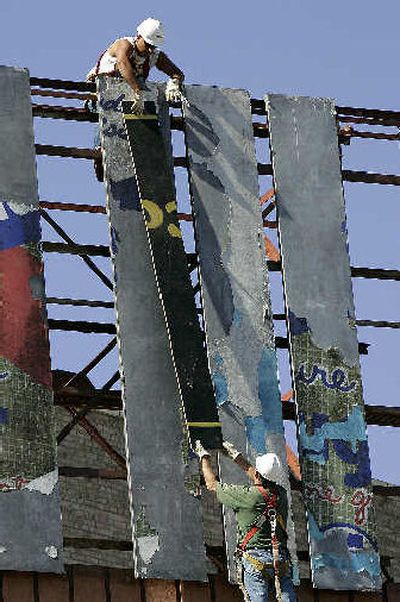 
Gene Boswell, top, and Jimmy Manit work to repair a billboard on Canal Street in New Orleans on Monday. 
 (Associated Press / The Spokesman-Review)