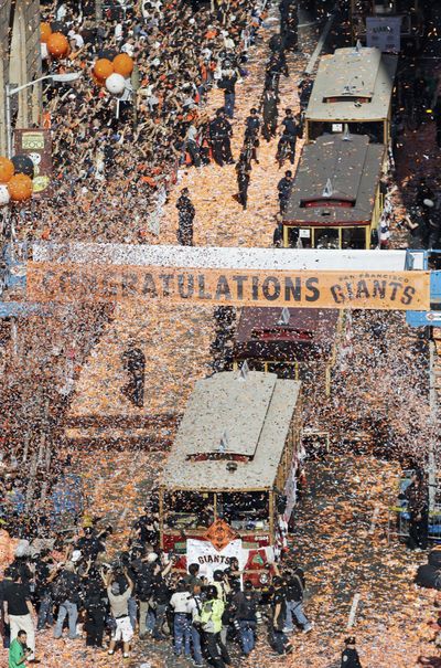 The San Francisco Giants travel on motorized cable cars during Wednesday’s ticker-tape parade for the World Series champs.  (Associated Press)