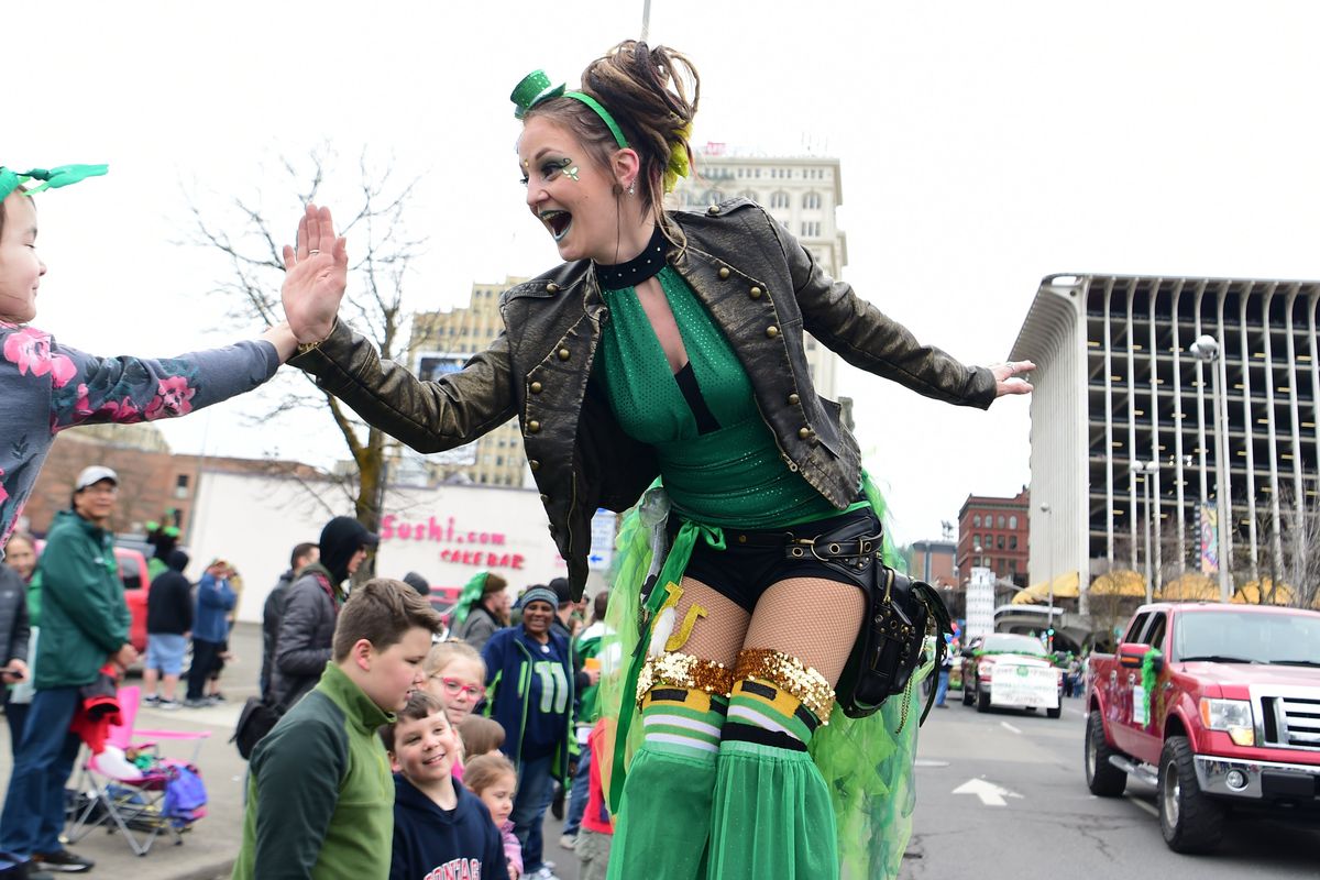Stilt walker Ashley Werner leans down to high-five children along the parade route in the annual St. Patrick’s Day Parade on March 17, 2018, in downtown Spokane. The parade has been canceled for the past two years but is scheduled again for this Saturday.  (JESSE TINSLEY)