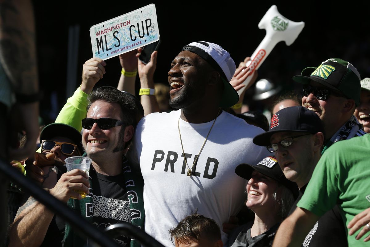 Portland Trail Blazers NBA basketball center Festus Ezeli, center, joins Portland Timbers fans cheering at the end of an MLS soccer match against the Seattle Sounders on Sunday. (Ted S. Warren / Associated Press)