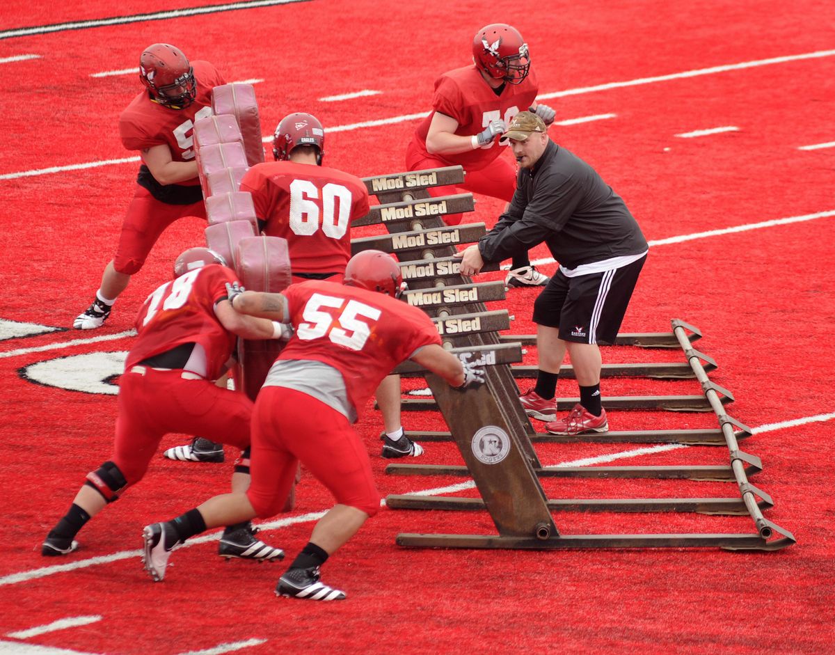 During a tackling exercise, Eastern Washington offensive line coach Aaron Best works with his players during spring ball in 2012. (Colin Mulvany / The Spokesman-Review)