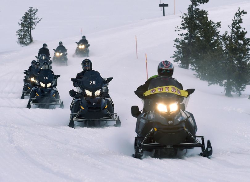 Snowmobilers cruise in Yellowstone National Park, where visitor numbers continue to grow. (Hannah Potes / Associated Press)