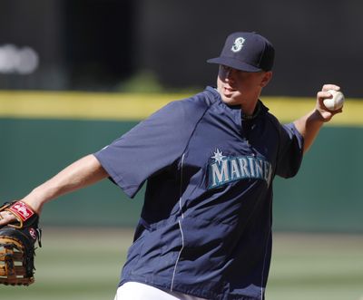  Justin Smoak warms up before his Mariners debut Saturday. He went 0 for 4.  (Associated Press)