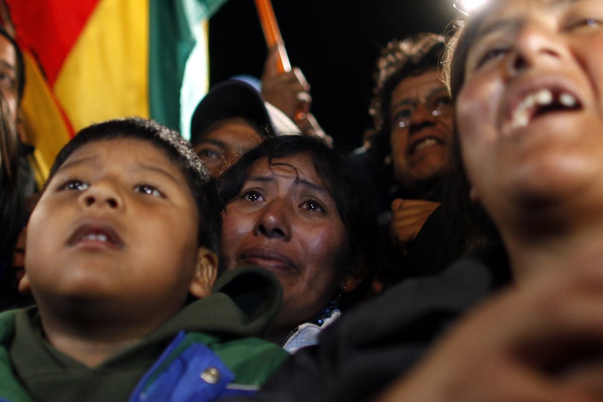 Relatives of trapped Bolivian miner Carlos Mamani Solis react while watching his rescue on a TV screen at the camp outside the San Jose mine near Copiapo, Chile, early Wednesday, Oct. 13, 2010. (Natacha Pisarenko / Associated Press)