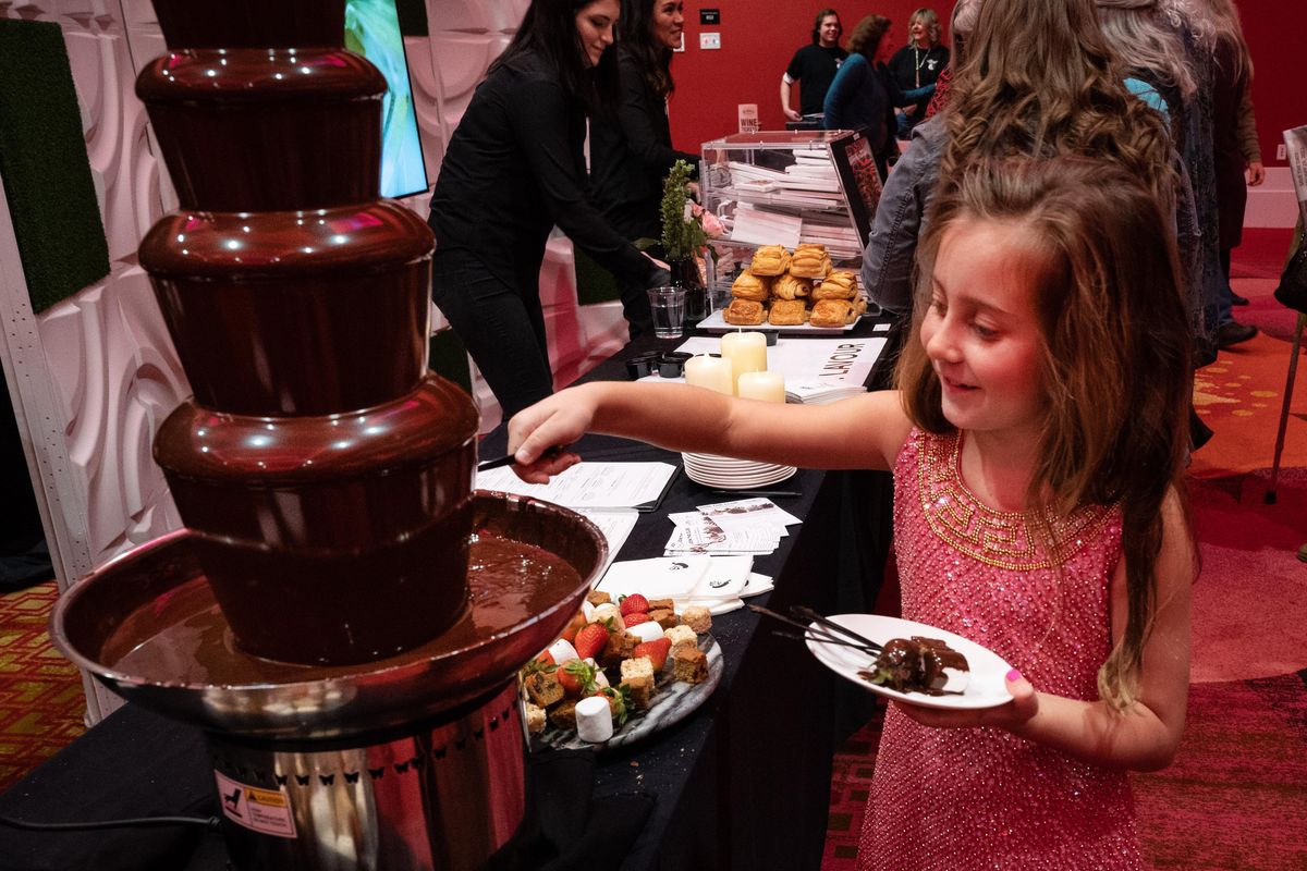 Presley Hodgson, 7, dips a strawberry in the Melting Pot’s chocolate fondue during the Decadence Chocolate Festival on Friday, Feb. 7, 2020, at the Davenport Grand. (Colin Mulvany / The Spokesman-Review)