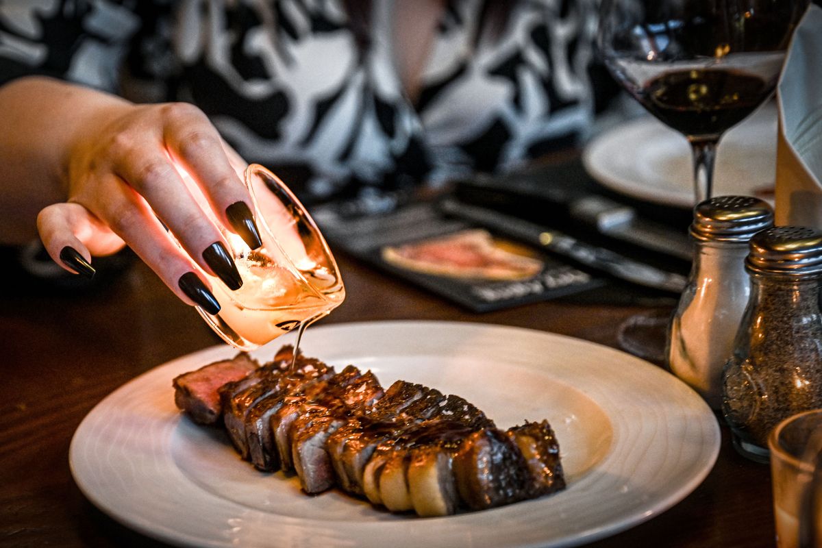 Beef tallow candle drippings is poured over a Chinook dry-aged steak at the Coeur d’Alene Casino Resort Hotel on April 30.  (Kathy Plonka/The Spokesman-Review)