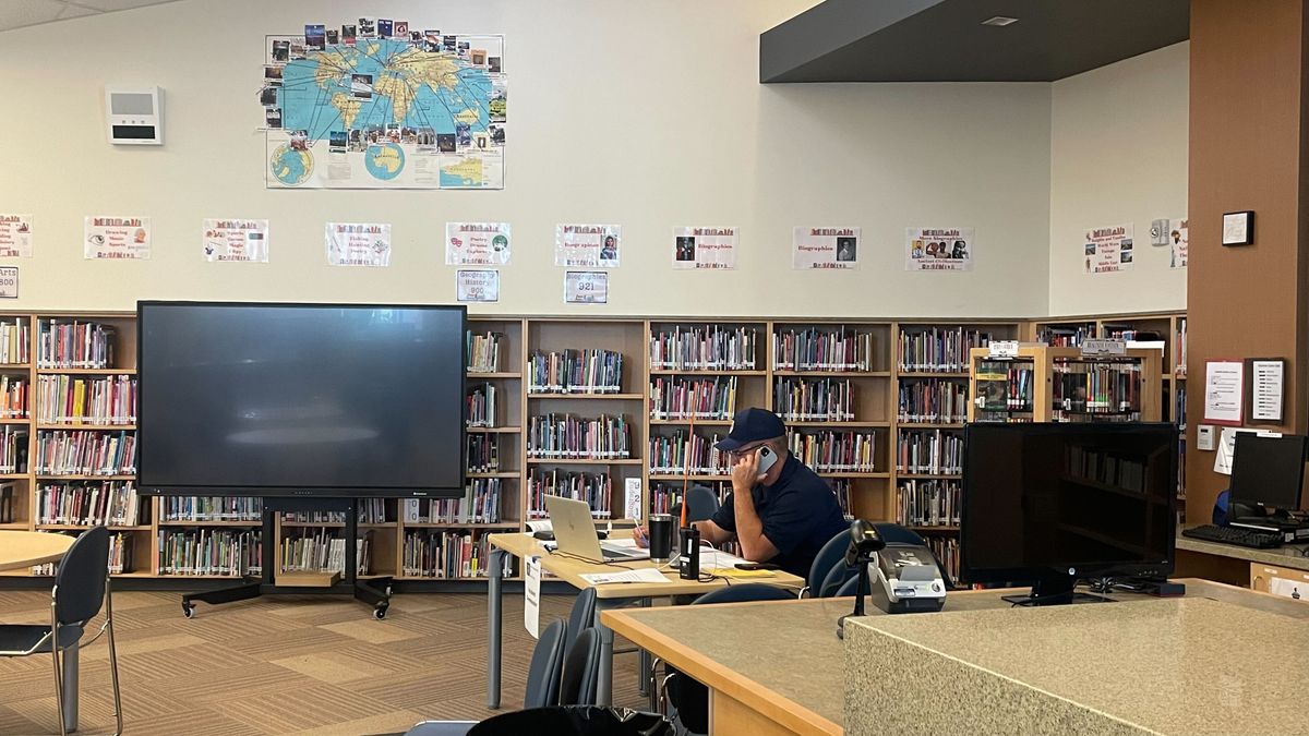 Andrew Stenbeck sits at his makeshift desk at the Cheney Middle School library on Saturday, July 27. He is the incident commander for two Spokane County fires that sparked Friday.  (Alexandra Duggan / The Spokesman-Review)