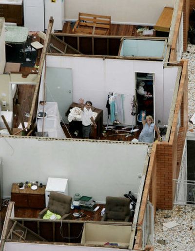 
Residents wave from their roofless apartment in Innisfail in northern Queensland today. Cyclone Larry ripped roofs off buildings across Australia's northeastern coast. 
 (Associated Press / The Spokesman-Review)