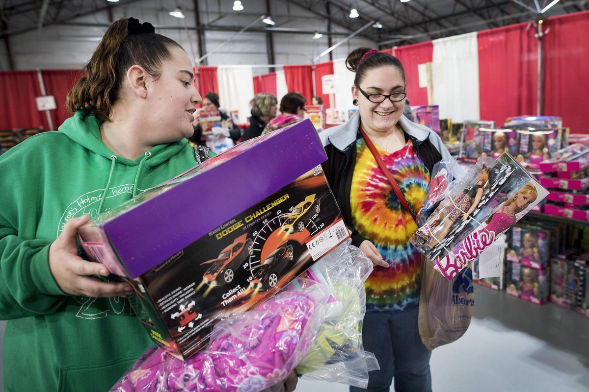 In the toy room, Amber Squires, left, and Jamie Wilson find the perfect gifts for their children on the opening day of the Christmas Bureau , Friday, Dec. 8, 2017, at the Spokane Fair And Expo Center. (Colin Mulvany / The Spokesman-Review)